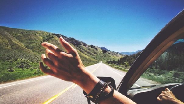 mano fuera del coche en la carretera